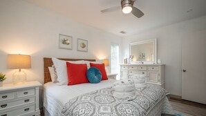 A bedroom with a bed, nightstands, a dresser, a mirror, and a ceiling fan. - 55 Lawton: Pet Friendly, Modern Luxury, Remodeled Sea Pines Home. Free Bikes (Hilton Head Island)