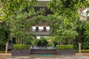 A courtyard with a fountain, steps leading up to a building, and lush greenery. - Tree of Life Tiger Trails, Ranthambore (Sawai Madhopur)