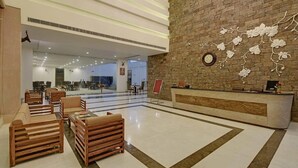 A spacious lobby with a reception desk, wooden furniture, and a decorative wall. - Tree of Life Tiger Trails, Ranthambore (Sawai Madhopur)