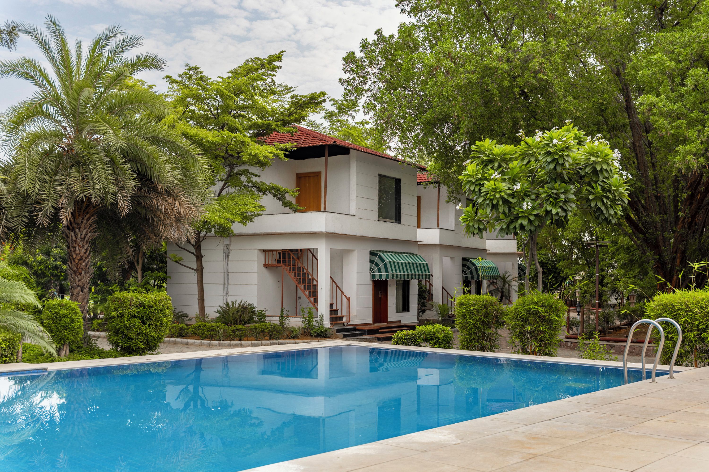 Un edificio de dos pisos con una piscina delantera.