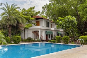 Un bâtiment à deux étages avec une piscine devant.