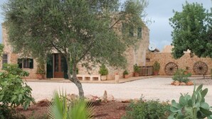 A rustic building with a stone facade, a green door, and a gravel courtyard. - Rural estate with pool and professional tennis court (LLucmajor)