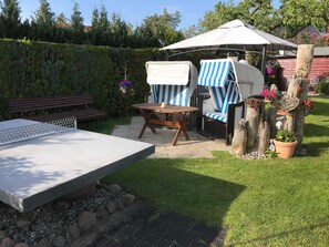 An outdoor seating area with a table, chairs, and a bench. - Haus Schumann - Ostsee - Halbinsel Darss - Ferienwohnung (Wieck a. Darß)
