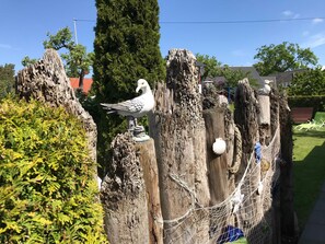 A wooden fence with bird sculptures and a hammock. - Haus Schumann - Ostsee - Halbinsel Darss - Ferienwohnung (Wieck a. Darß)