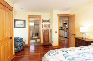 Ein Schlafzimmer mit einem Bett, einem Holzschrank und einem Badezimmer mit Dusche und Toilette.