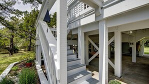 Ein weißes Gebäude mit einer Veranda und Treppen zu einem überdachten Eingang.