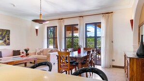 Un salón amplio con una mesa de comedor, sillas, un sofá y una mesa de centro.
