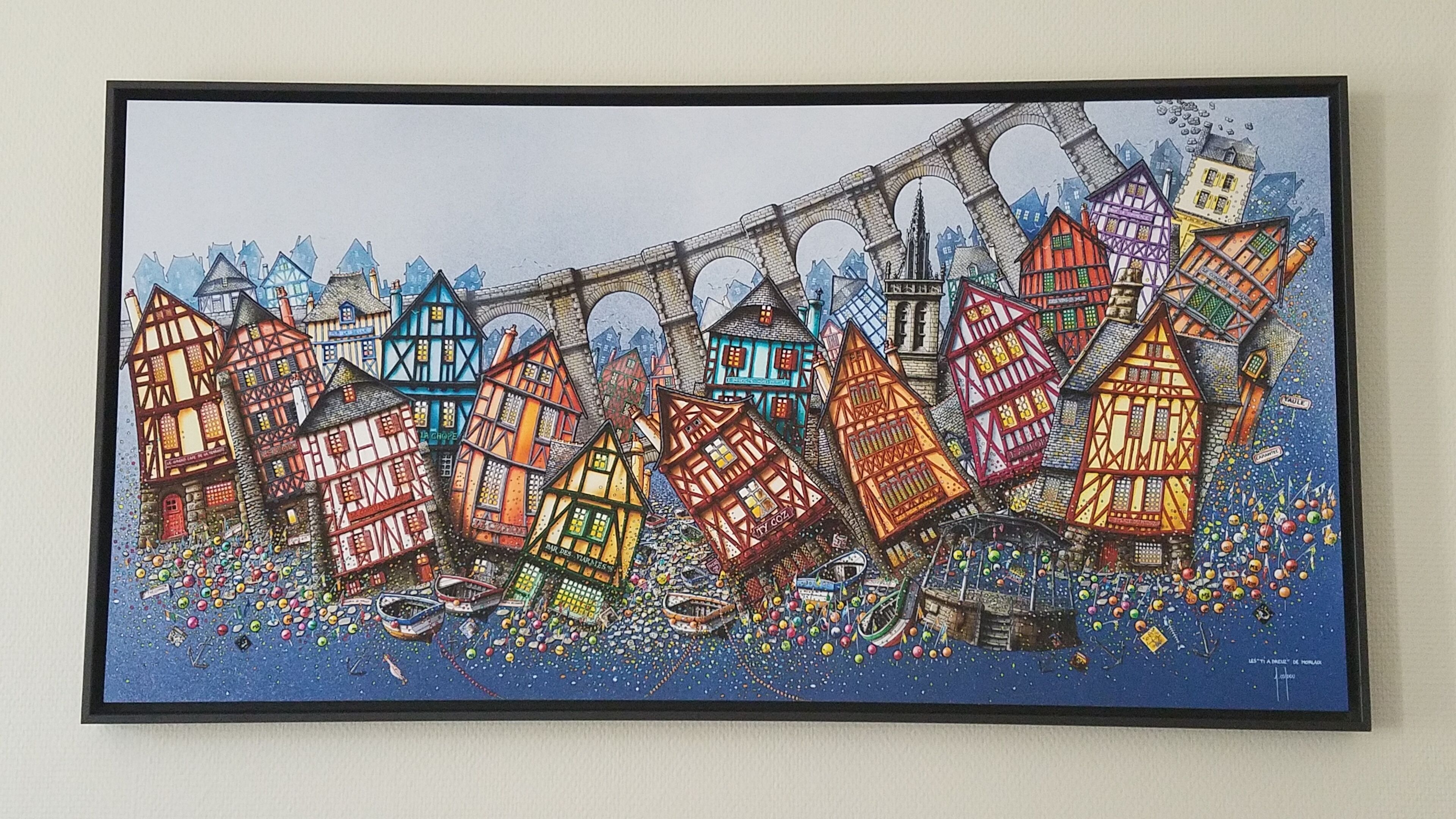 A colorful illustration of a town with various buildings and a bridge.