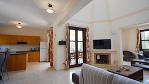 Un espacio habitable compacto con cocina, comedor y sala de estar con chimenea.