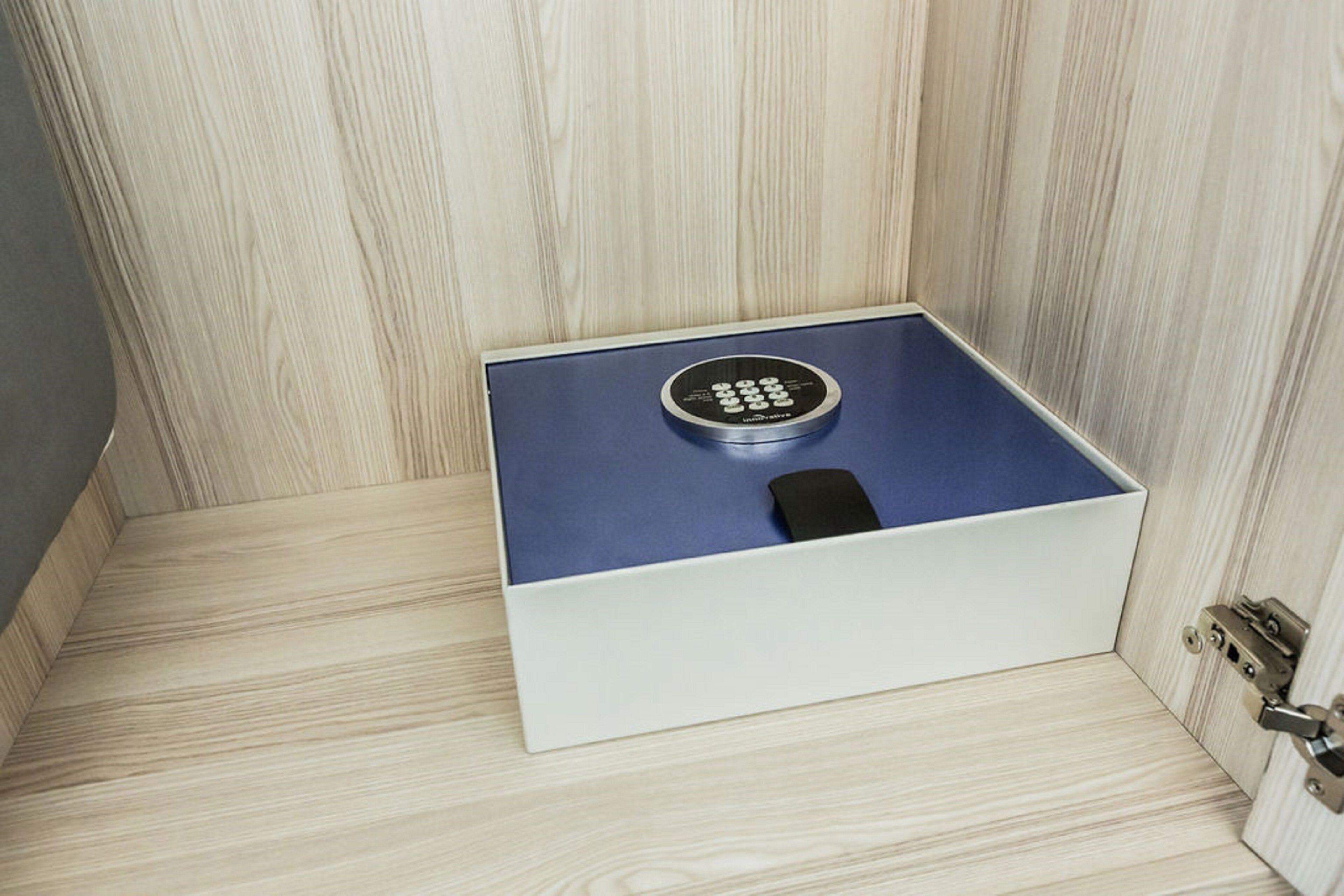 Una caja de seguridad con cerradura de combinación, sobre un piso de madera.