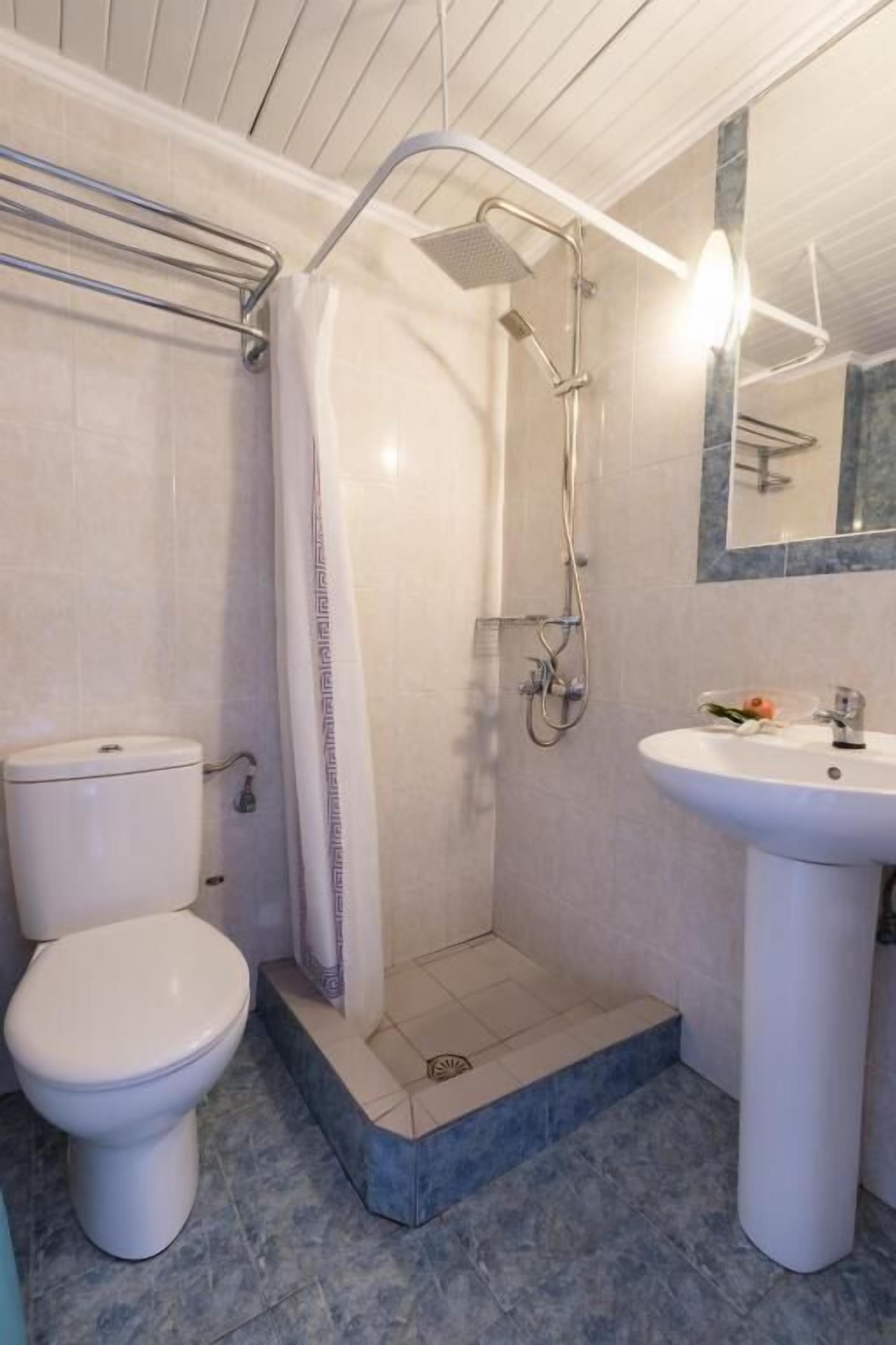 Ein Badezimmer mit Dusche, Toilette und Waschbecken.