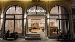 The exterior of Hotel Atlantis with a clear entrance, two motorcycles parked in front, and a reception area visible through the glass doors. - Atlantis Hotel (Karpathos)