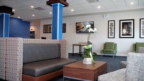 Een moderne lobby met een zithoek, een bijzettafeltje en kunstwerken aan de wanden.