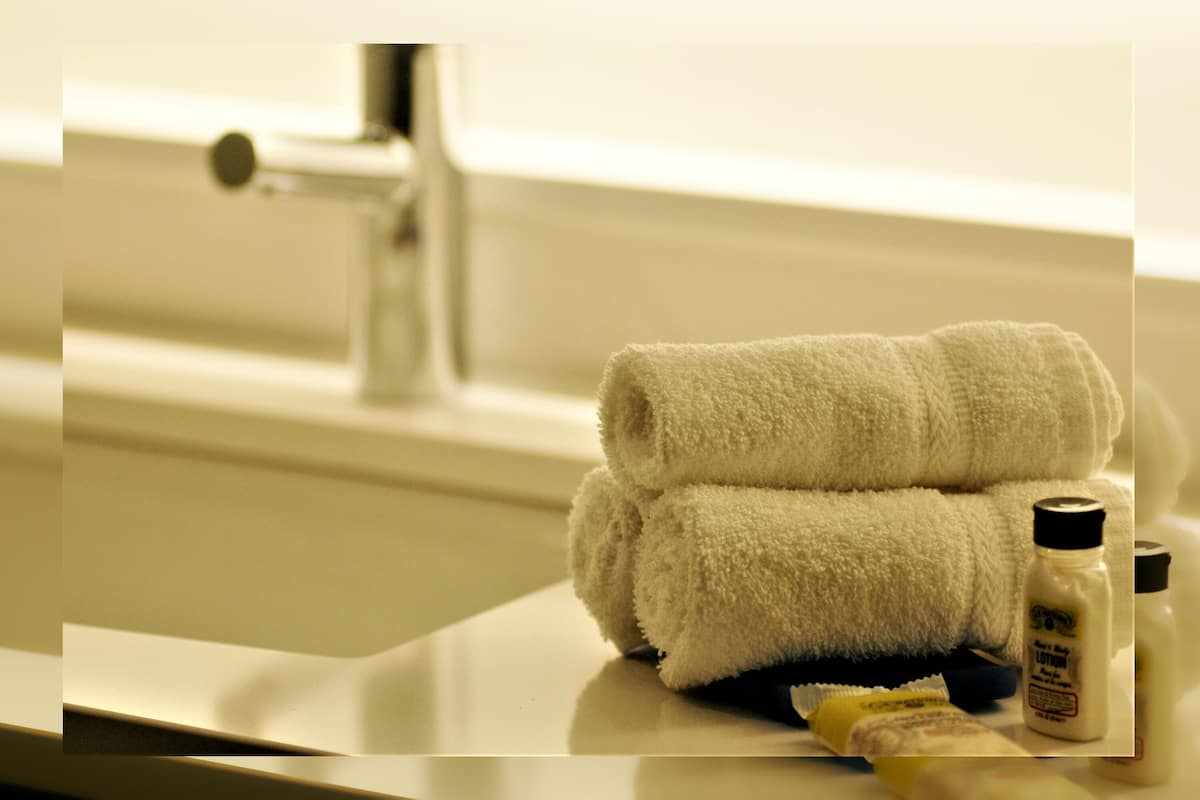 Une salle de bain équipée d’un lavabo, d’une serviette et d’articles de toilette.