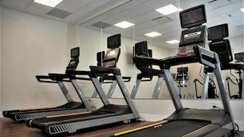 A gym with treadmills, mirrors, and exercise equipment.