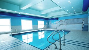 An indoor swimming pool with clear markings, a tiled floor, and a staircase leading to an upper level. - Holiday Inn Express & Suites Edmonton SW - Windermere by IHG (Edmonton)