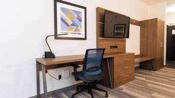 Un espacio de oficina moderno con un escritorio, una silla y un televisor montado.