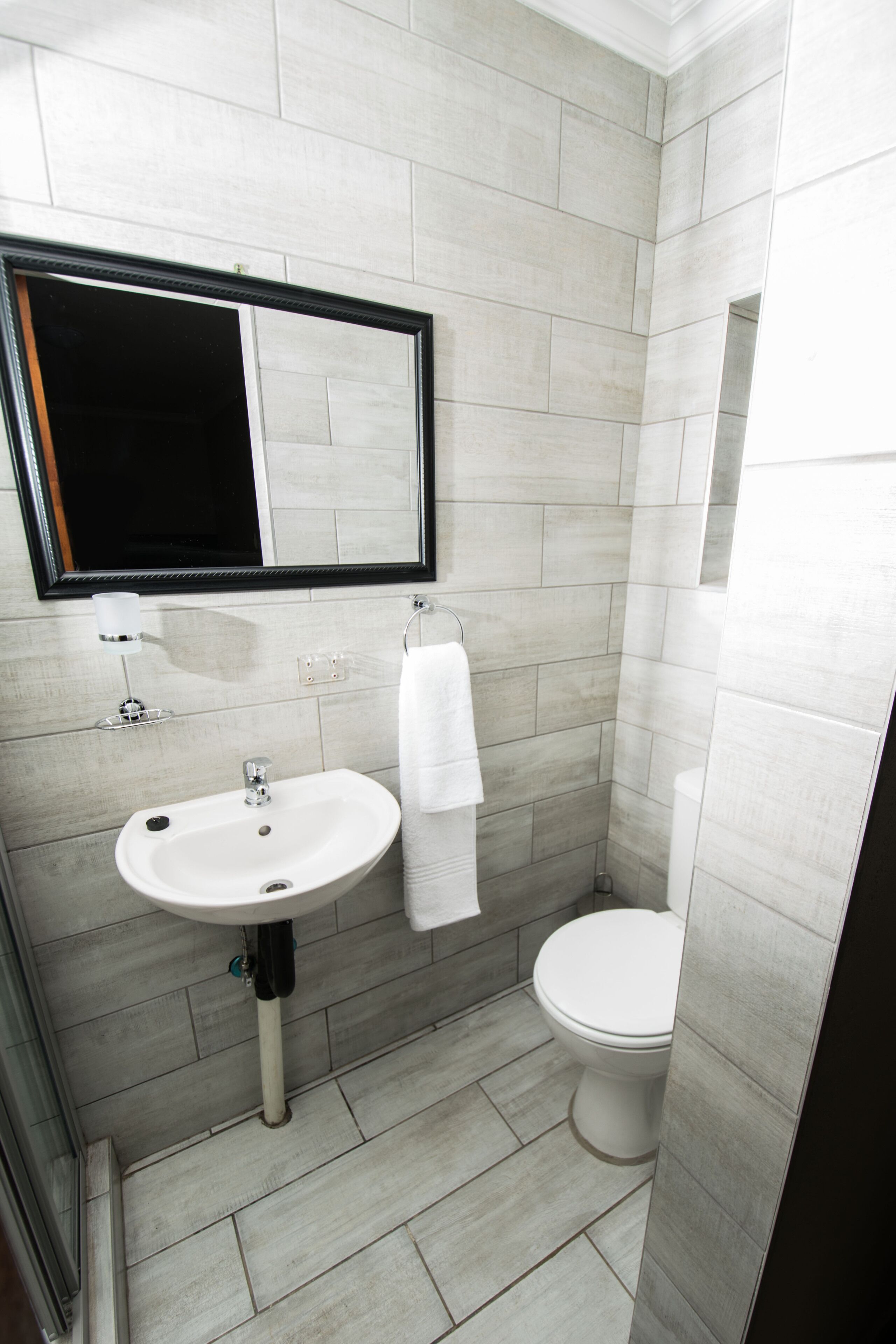 Un baño con lavabo, espejo e inodoro.