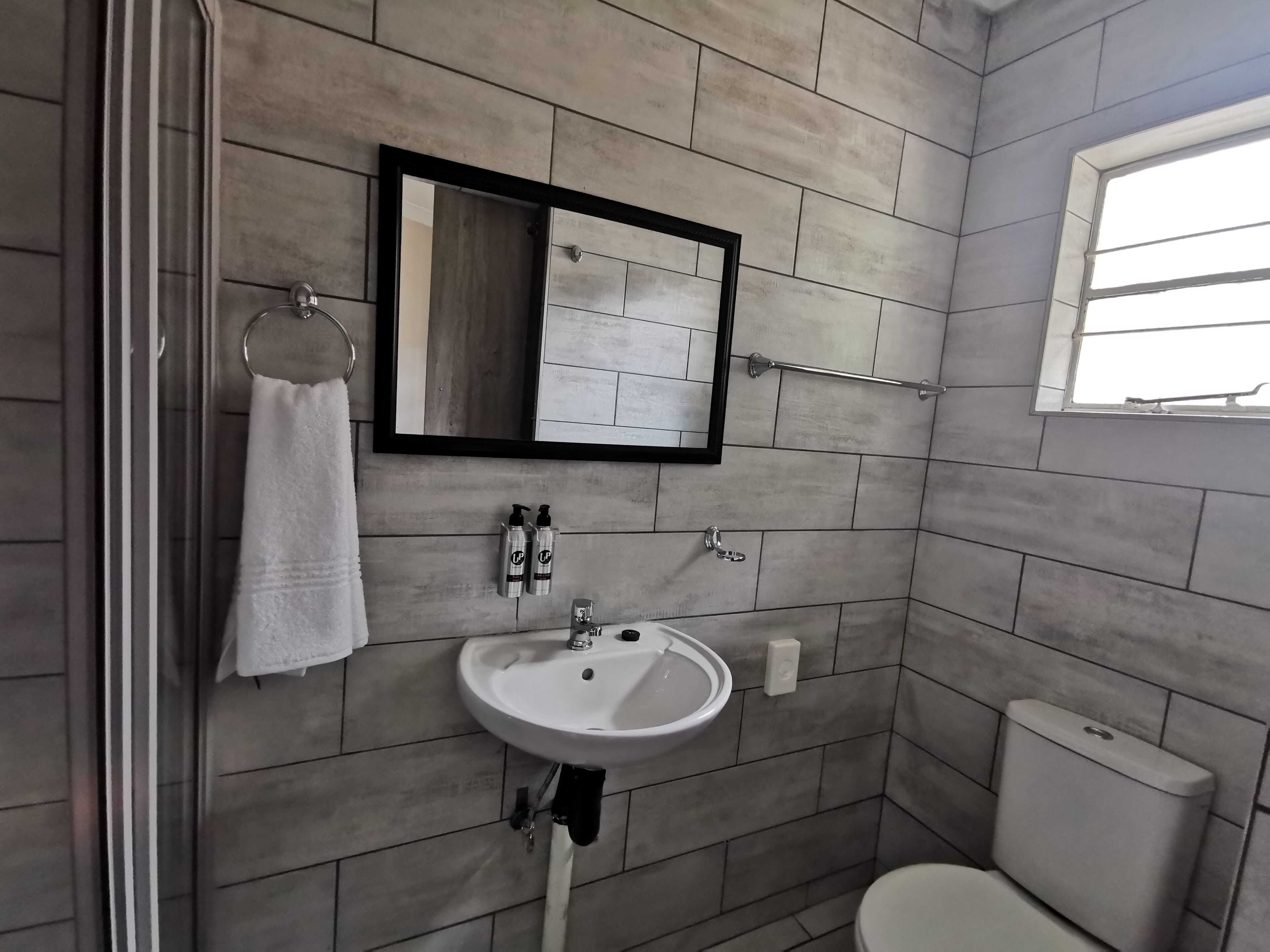 Un baño con lavabo, espejo y retrete.