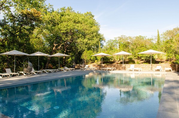 Piscine couverte, piscine extérieure, parasols de plage, chaises longues