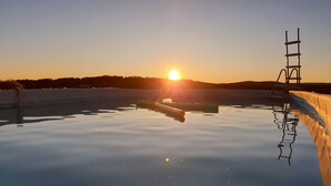 A swimming pool at sunset with a ladder on the right side. - Entire villa 230 m2 with magnificent view (Blars)