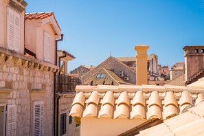 Un bâtiment traditionnel en pierre, avec un toit en tuiles et des volets blancs.