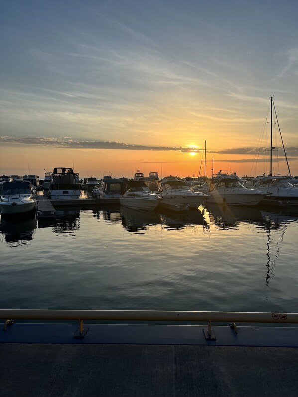 A marina with multiple boats docked at sunset.