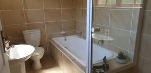 A bathroom with a toilet, sink, and bathtub. - High Grove Cottage (Cape Town)