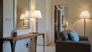 A modern living room with a sofa, two lamps, a console table, and a mirror. - Apartment DD12 - Chloe (Kouklia)
