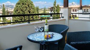 A balcony with a round table, two wine glasses, a bottle of wine, and a flower arrangement. - Apartment DD12 - Chloe (Kouklia)