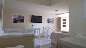 A hotel room with a bed, a desk, a chair, and a television on the wall. - Pousada 14 Bis (Petrópolis)