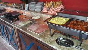 A buffet with various food items, including meats, cheeses, and baked goods. - Pousada 14 Bis (Petrópolis)