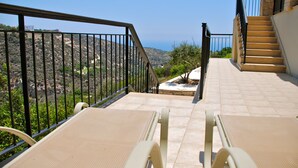 Una terraza con dos sillones de descanso, una escalera de piedra y vistas al paisaje.