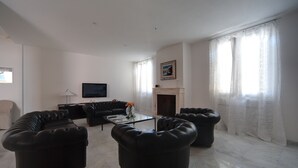 A living room with a sectional sofa, a coffee table, and a flat-screen TV. - Forte Inn (Forte dei Marmi)
