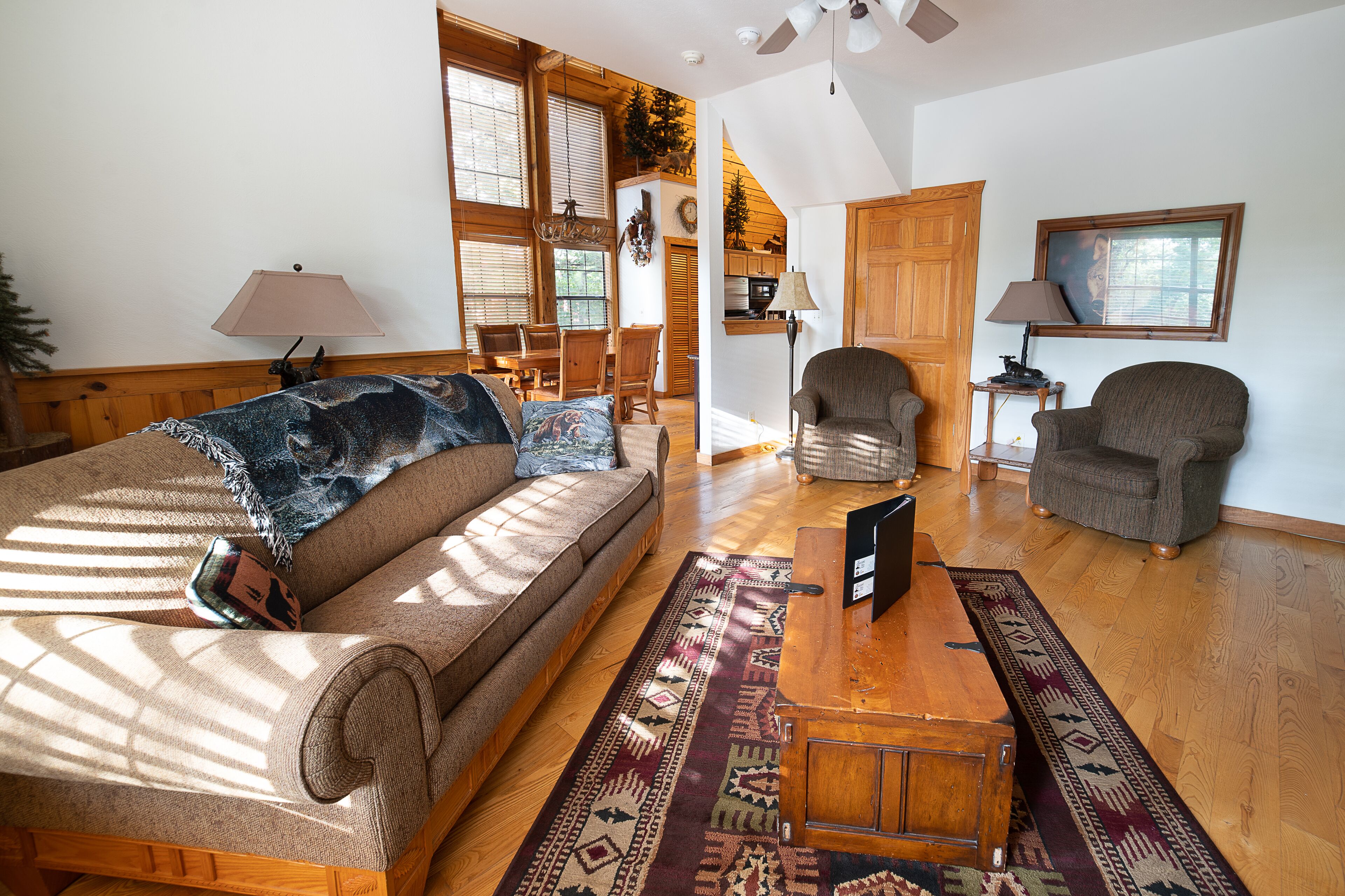 A cozy living room with a sofa, two armchairs, a wooden coffee table, and a rug.
