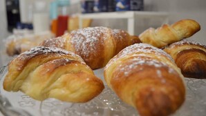 Una presentación de pastelería, probablemente croissants, sobre un plato de vidrio.