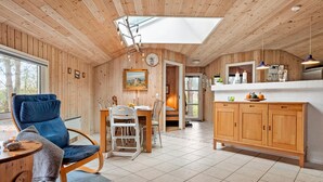 Ein gemütliches Holzinterieur mit Essbereich, einer Küche und einem großen Oberlicht.