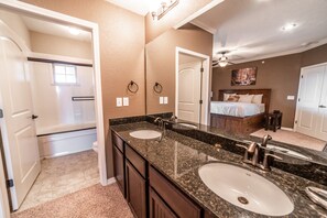 A bathroom with two sinks, a mirror, and a ceiling fan.