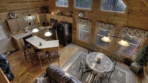 A cozy cabin with a kitchen, dining area, and a living room with a fireplace.