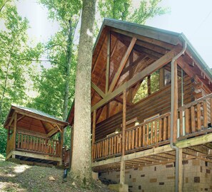 Eine Holzhütte mit Balkon, umgeben von Bäumen.