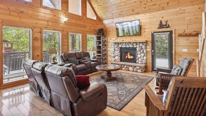 A spacious living room with a fireplace, leather recliners, and a large TV. - Hillbilly Hilton #525 (Gatlinburg)