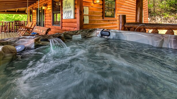 Una cabaña de madera con jacuzzi, mobiliario exterior y un cartel que dice "This is our Gappy Place".