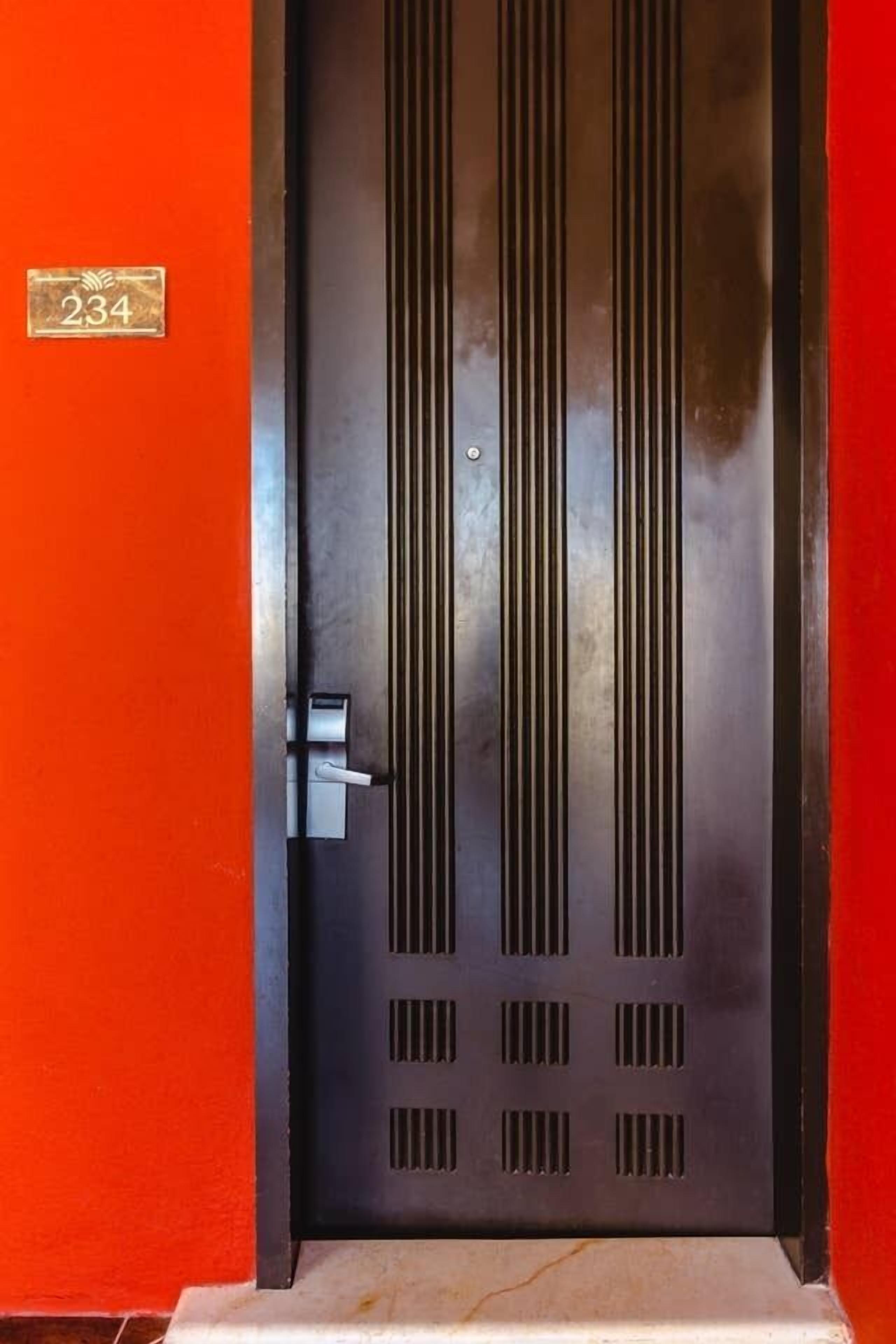 A door with a number plate, a vertical handle, and a keyhole.