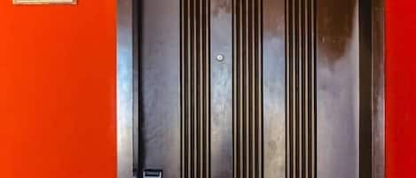 A door with a number plate, a vertical handle, and a keyhole.