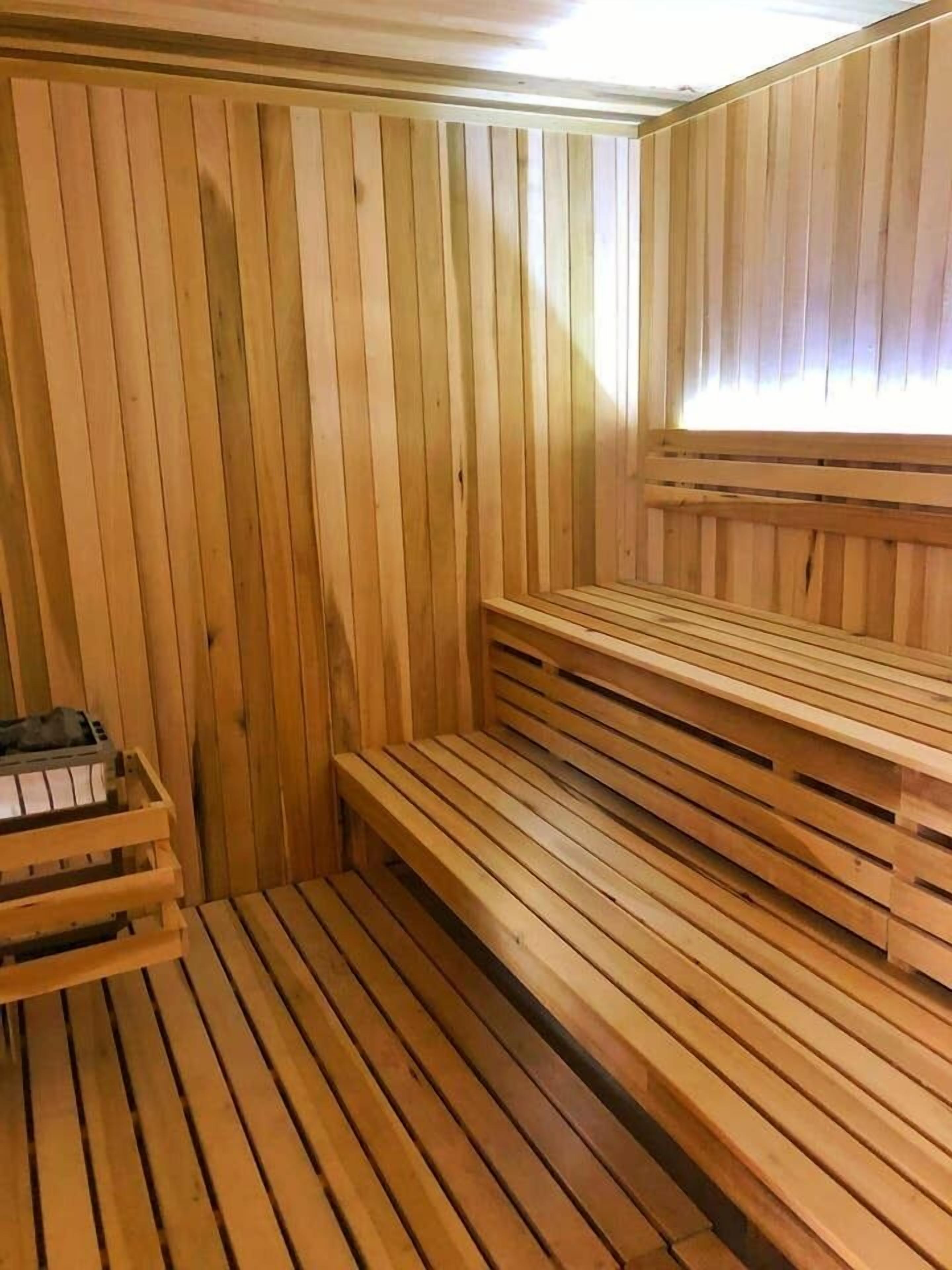 Eine Holzsauna mit Bänken und einer Sitzbank.