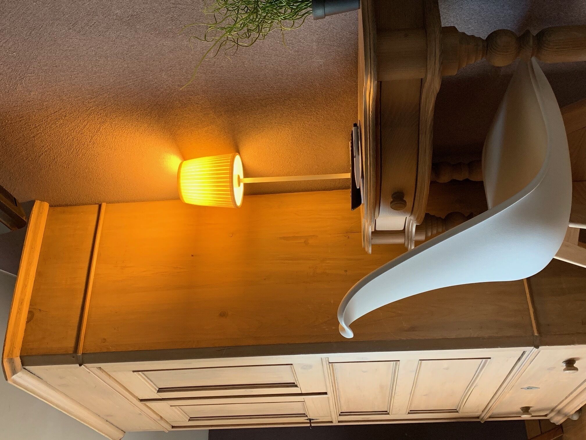 A ceiling with a light fixture and a curved white structure.