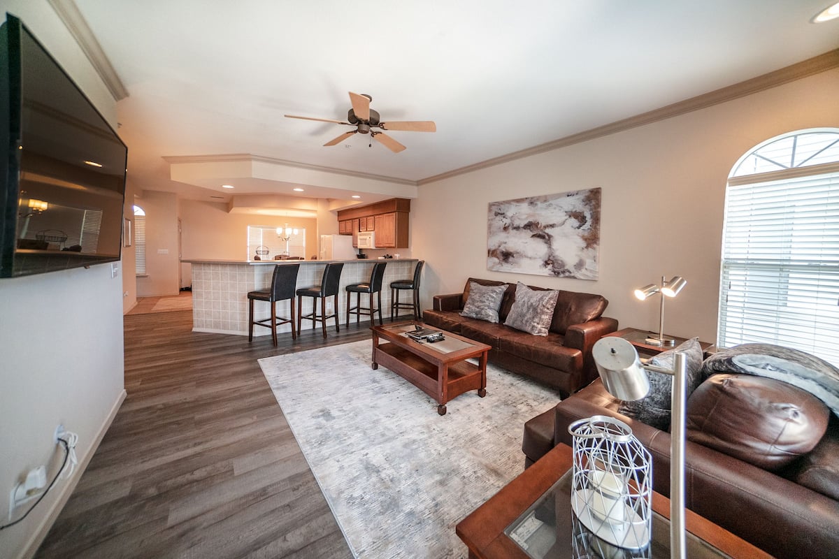 A modern living room with a sofa, coffee table, and a dining area with chairs.
