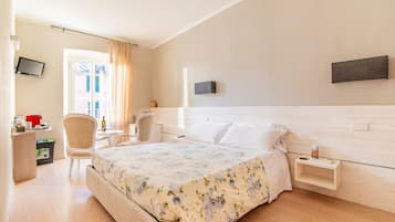Ein Hotelzimmer mit Bett, Schreibtisch, Stuhl, Fernseher und Fenster.