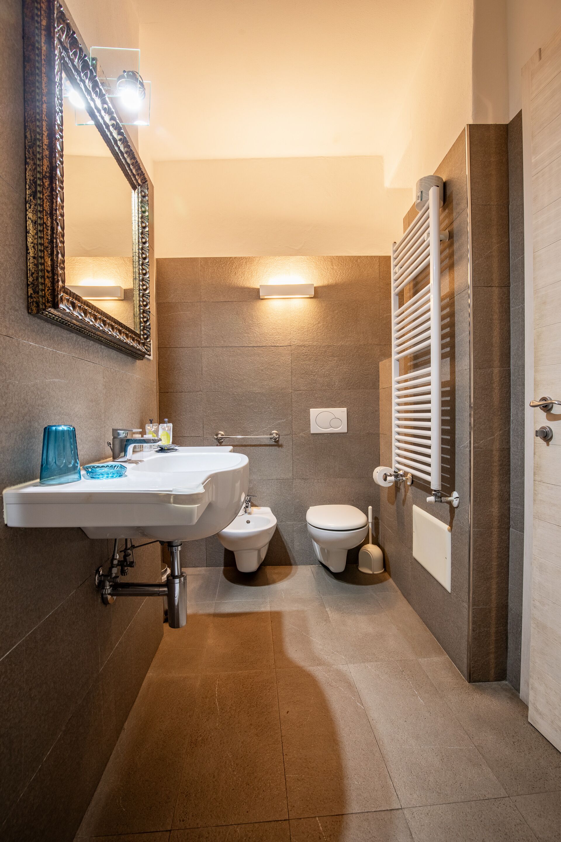 A modern bathroom with a white sink, a mirror, a toilet, and a shower area.