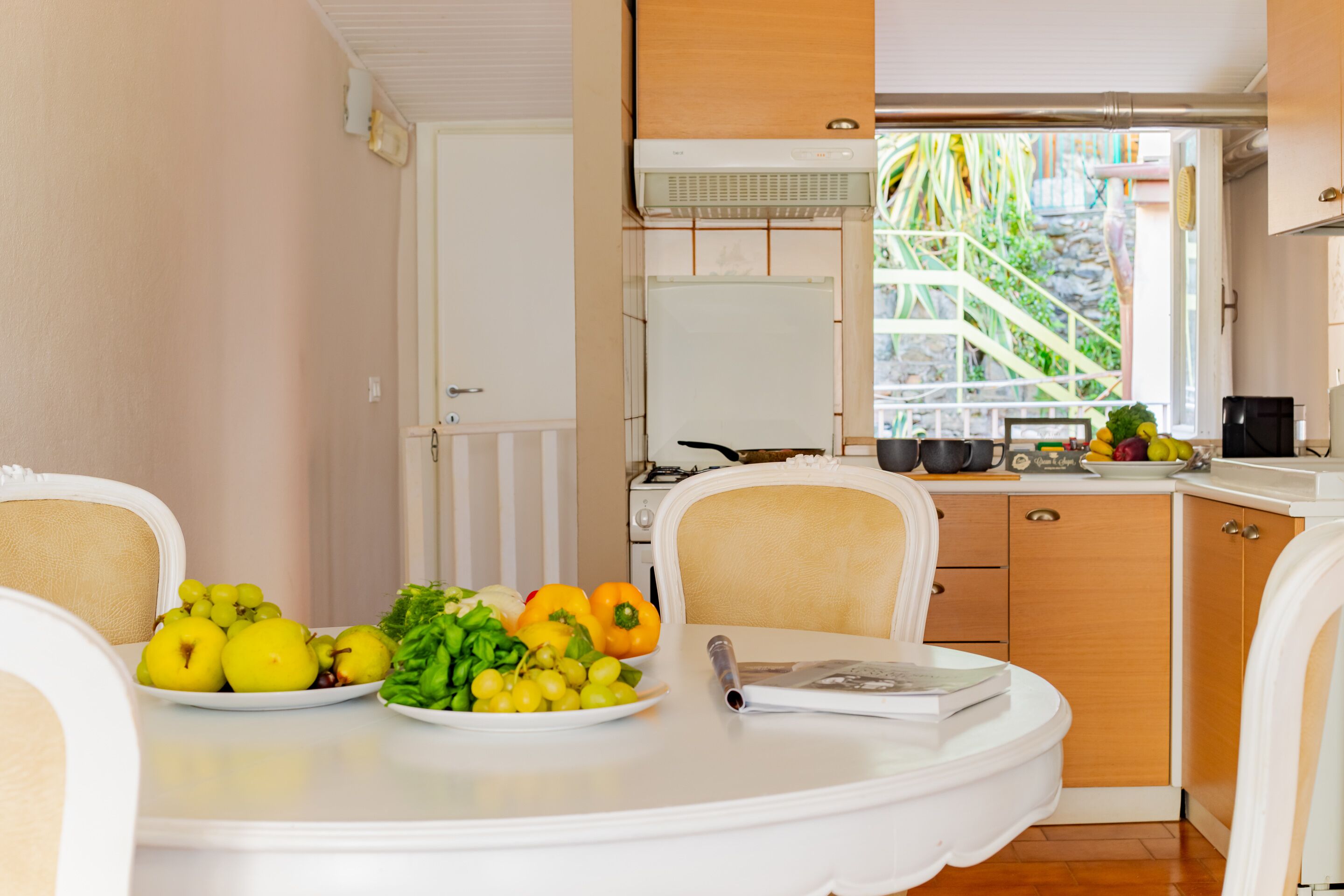Un coin repas avec une table dressée pour deux personnes, où l’on peut voir des assiettes remplies de fruits et de légumes.